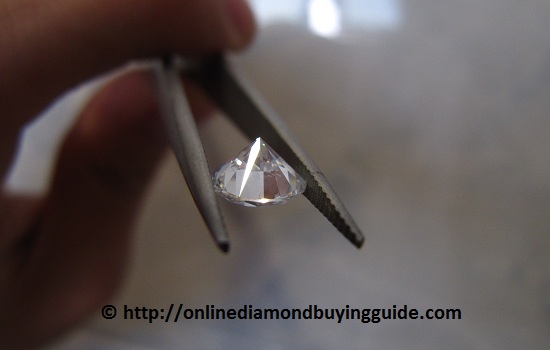 picking up a diamond with tweezers upside down