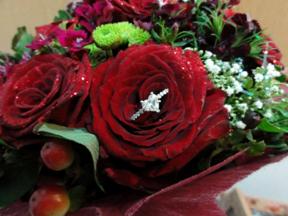 placing the ring into red roses