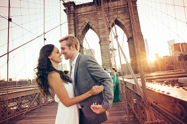 couple taking wedding photos at a bridge